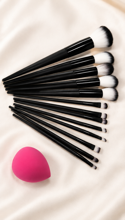 Makeup brush set fanned out on cream silk with pink blending sponge